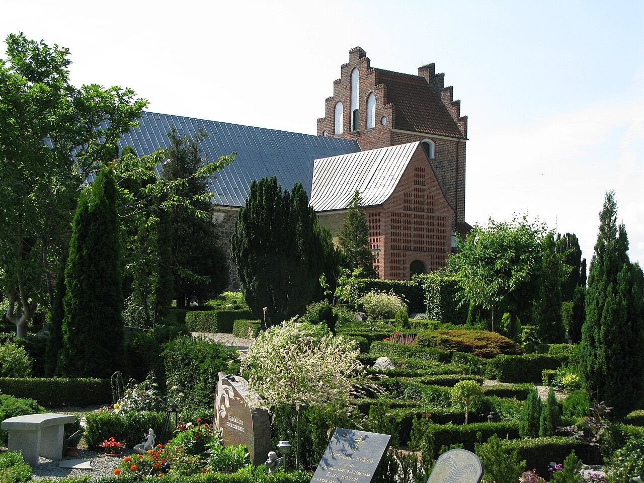 Smørum Church and its green churchyard, with the red brick northern extension.