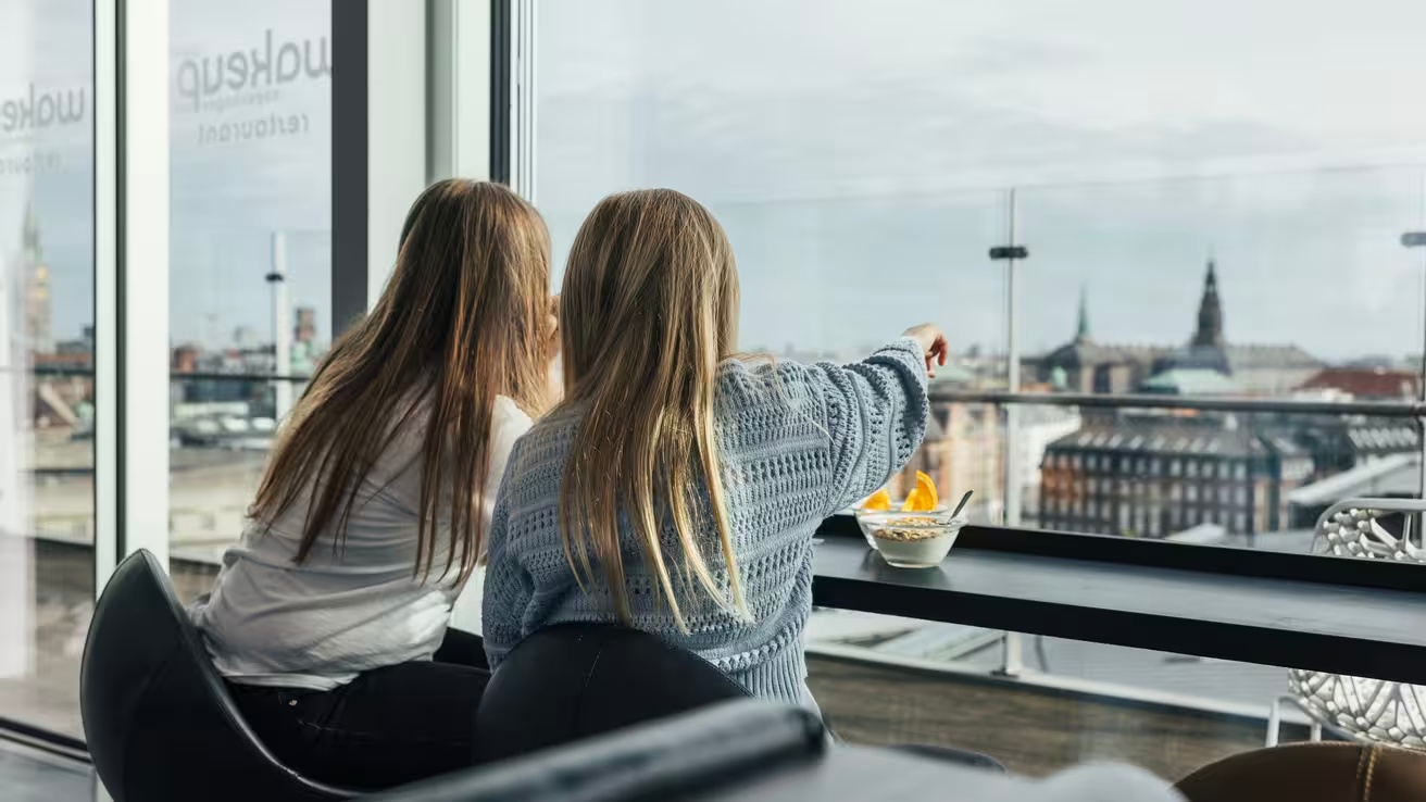 Guests looking out over Copenhagen from the breakfast area at Wakeup Copenhagen.